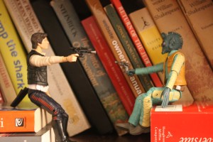 My apologies. Mr. Battler was too cheap to spring for a doll house table. Assume Greedo can't see Han's piece, thus giving the rogue pilot the element of surprise.